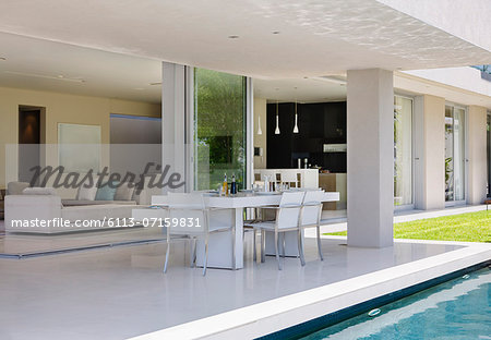 Set table on patio by pool of modern house