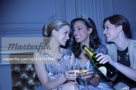 Well dressed women drinking champagne in luxury nightclub