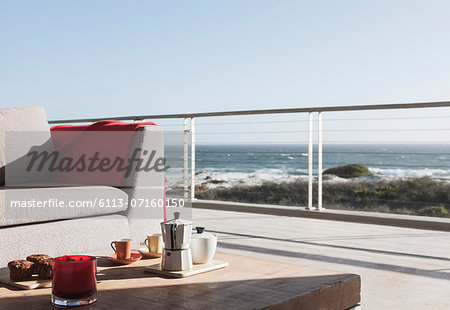 Breakfast on coffee table on modern patio overlooking ocean Breakfast on coffee table on modern patio overlooking ocean