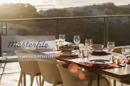 Set table in modern dining room open to balcony