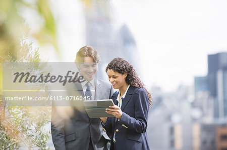 Business people using digital tablet outdoors