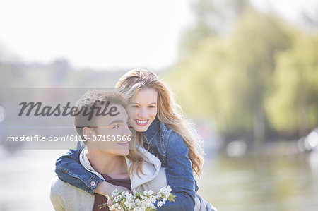 Man carrying girlfriend outdoors