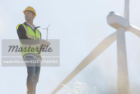 Worker by wind turbines in rural landscape