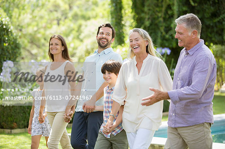 Multi-generation family walking in backyard