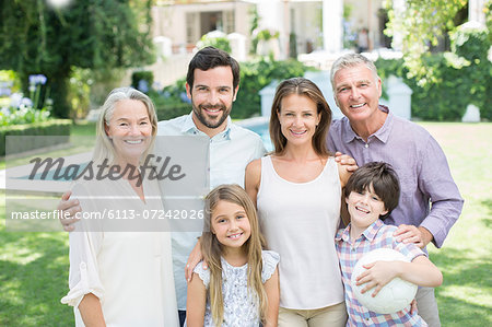 Multi-generation family smiling in backyard Multi-generation family smiling in backyard