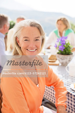 Senior woman smiling at patio table