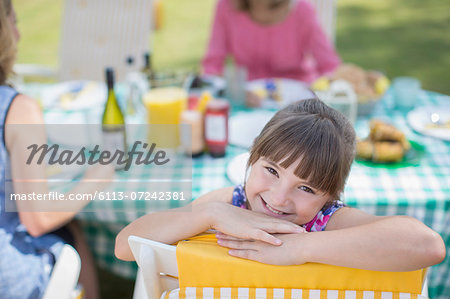 Girl smiling at table in backyard