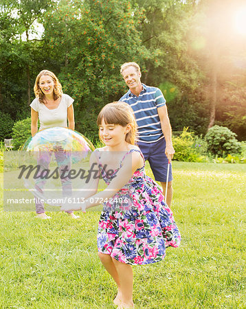 Family playing with bubbles in backyard