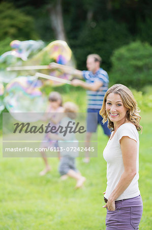 Family playing with bubbles in backyard Family playing with bubbles in backyard