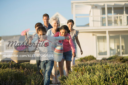 Family walking on beach path outside house Family walking on beach path outside house