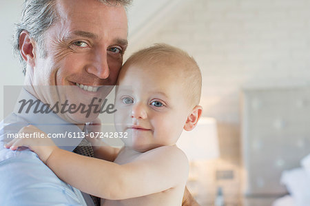 Father holding baby in bedroom