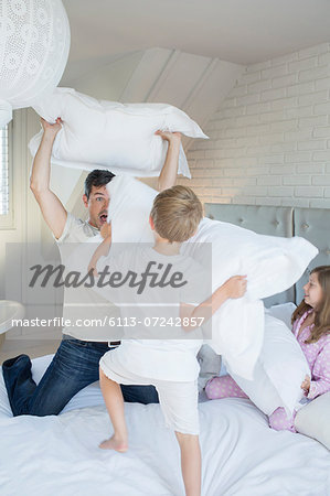 Father and children having pillow fight