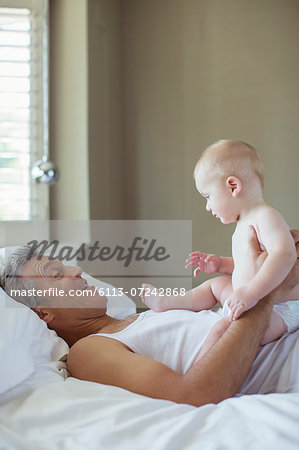 Father and baby relaxing on bed