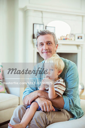 Father holding son in living room