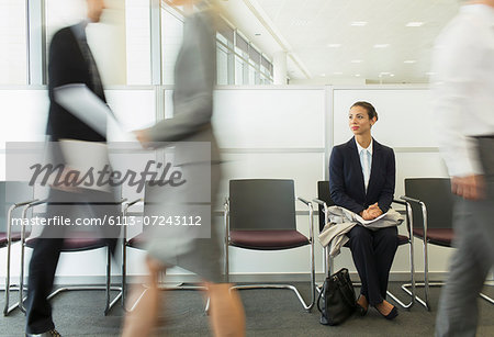 Businesswoman sitting in busy waiting area