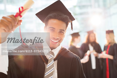 Smiling graduate holding diploma