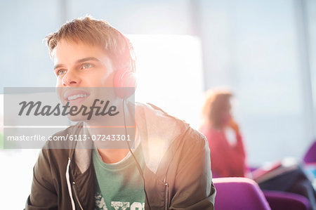 Young man listening to headphones indoors