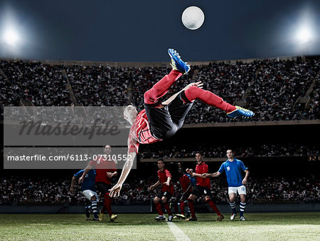 Soccer player kicking ball on field