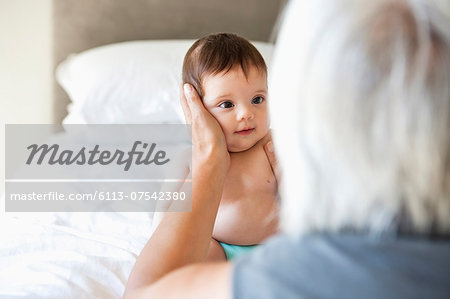 Woman holding granddaughter on bed