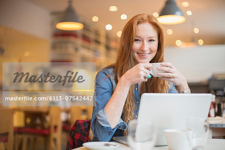 Woman using laptop in cafe