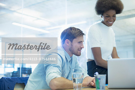 Business people using laptop in office