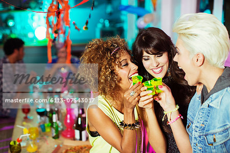Women taking shots at party Women taking shots at party
