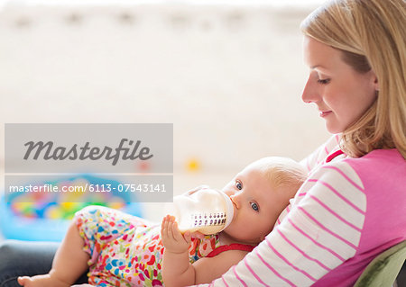 Mother feeding baby girl from bottle