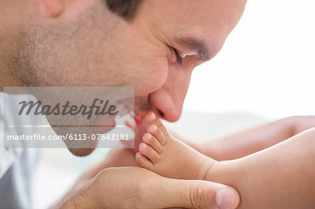 Father kissing baby boy's feet