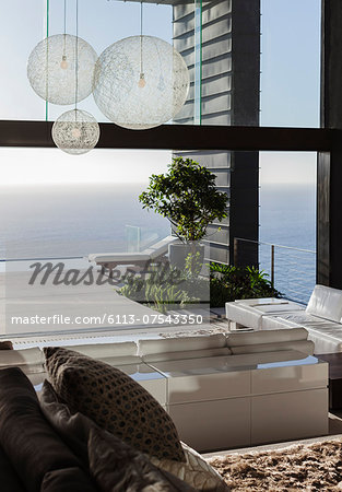 Sofas and tables in modern living room overlooking ocean Sofas and tables in modern living room overlooking ocean