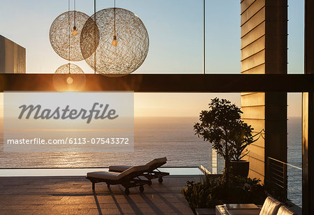 Patio of modern house overlooking ocean at sunset Patio of modern house overlooking ocean at sunset