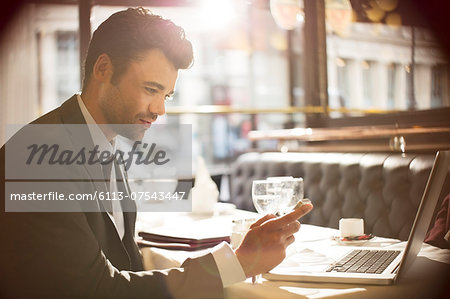 Businessman using laptop in restaurant