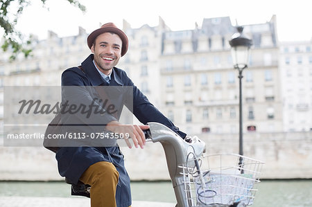 Businessman on bicycle along Seine River, Paris, France