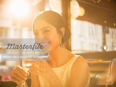 Well-dressed woman drinking champagne in restaurant