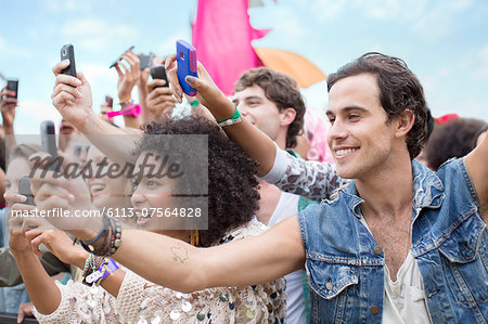 Fans with camera phones cheering at music festival