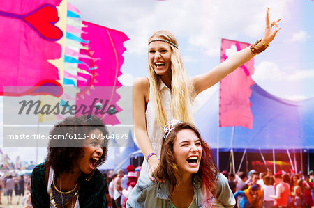 Woman piggybacking enthusiastic friend at music festival - Stock Photo -  Masterfile - Premium Royalty-Free, Code: 6113-07564879