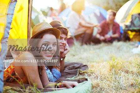 Portrait of couple laying in tent at music festival