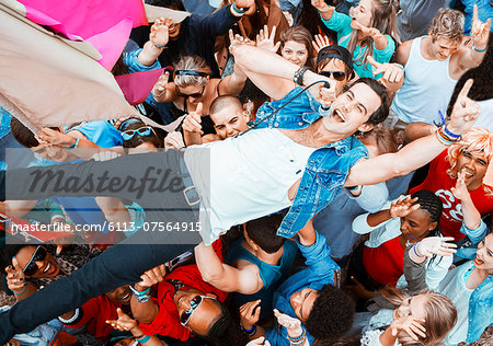 Performer singing and crowd surfing at music festival