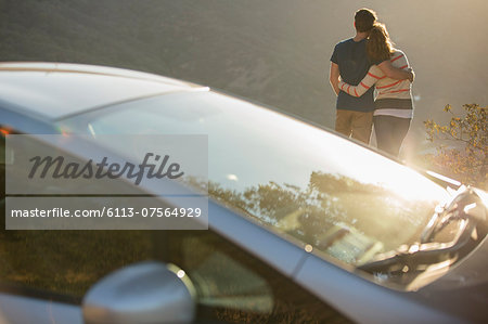 Couple hugging outside car at roadside