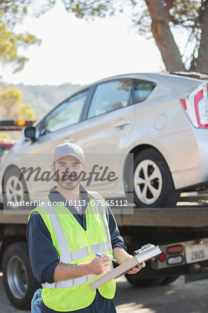 Portrait of confident roadside mechanic with paperwork