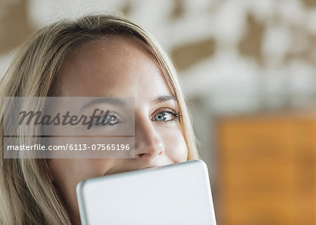 Close up portrait of woman behind digital tablet