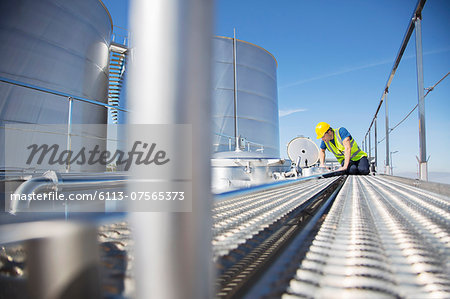 Worker on platform looking down into milk tanker