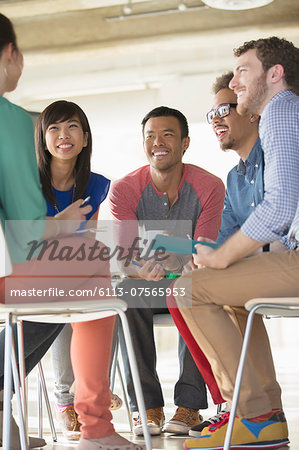 Creative business people meeting in circle of chairs