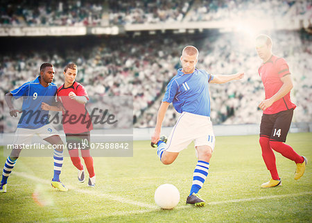 Soccer player kicking ball on field