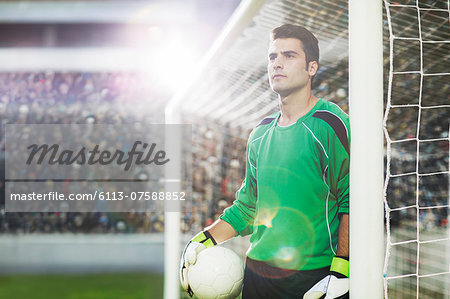 Goalie holding ball on soccer field