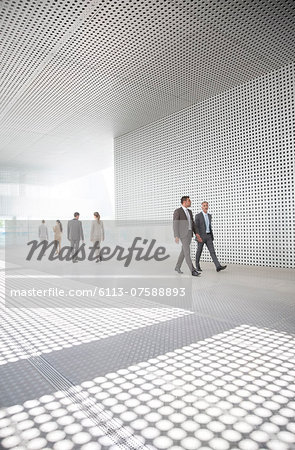 Business people walking in modern courtyard