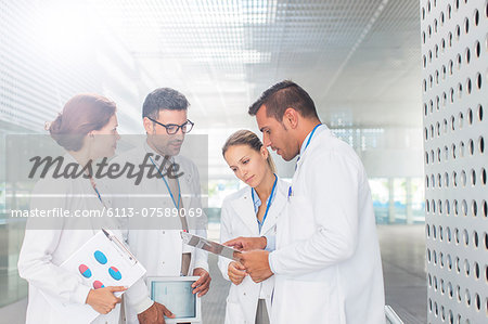 Doctors with clipboard talking in hospital corridor