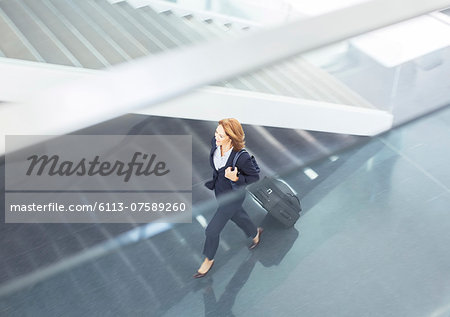 Businesswoman pulling suitcase in lobby