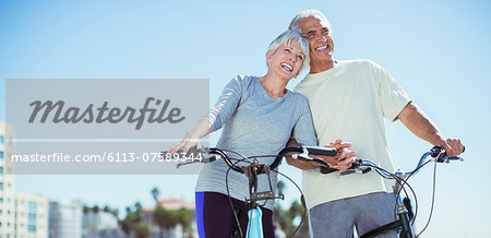 Senior couple with bicycles on beach