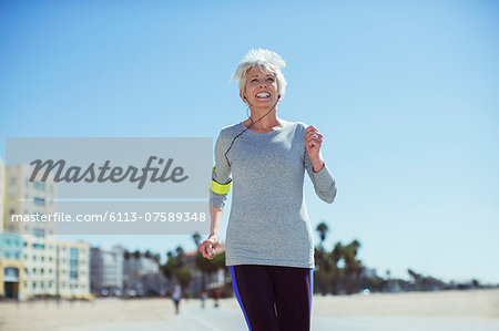 Senior woman power walking on beach