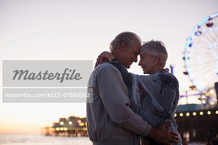Senior couple hugging on beach at sunset